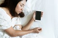 Top view portrait of a tired traveler woman sleeping in bed with mobile phone in hand. Social Addict concept. copy space Royalty Free Stock Photo
