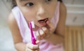 Top view portrait of worried small girl indoors, loosing baby tooth.