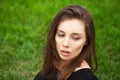 Top view portrait of a young beautiful woman in black dress lies on green lawn in a park Royalty Free Stock Photo