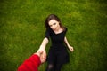 Top view portrait of a young beautiful woman in black dress lies on green lawn in a park Royalty Free Stock Photo