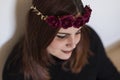 Top view portrait of a young beautiful woman wearing a red roses wreath. She is smiling, indoors. Lifestyle Royalty Free Stock Photo