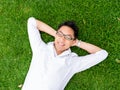 Ppretty young man in white shirt relaxing on a grass