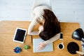 Top view portrait of young overworked businesswoman sleeping at the table