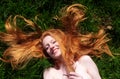 Top view portrait of young sexy beautiful redhead woman, happy content laughing relaxing, lying in the spring, summer sun, the red Royalty Free Stock Photo