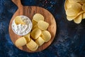 Top view potato chips, sauce in a white bowl on a wooden cutting board Royalty Free Stock Photo