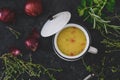 Top view of potato soup in white bowl with handle and lid on back background, decorated with red onions and herbs Royalty Free Stock Photo