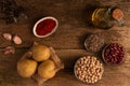 Top view of potatoes, 3 bowls of chickpea, red beans and lentil and other ingredients on the table