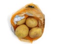 Top view of potatoes in orange net on white background Royalty Free Stock Photo