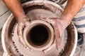 Top view of potter`s hand making a vase of white clay on throwing-wheel in ceramics studio, concept of creativity and art,