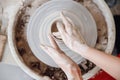 Top view of the potter wheel, hands of young woman make ceramic dishes from clay Royalty Free Stock Photo