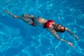 Top view of pregnant woman floating in pool in red bikini. Royalty Free Stock Photo