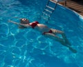 Top view of pregnant woman floating in pool in red bikini. Royalty Free Stock Photo