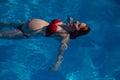 Top view of pregnant woman floating in pool in red bikini. Royalty Free Stock Photo