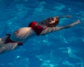 Top view of pregnant woman floating in pool in red bikini. Royalty Free Stock Photo