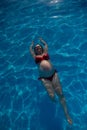 Top view of pregnant woman floating in pool in red bikini. Royalty Free Stock Photo