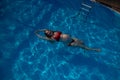 Top view of pregnant woman floating in pool in red bikini. Royalty Free Stock Photo