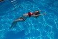 Top view of pregnant woman floating in pool in red bikini. Royalty Free Stock Photo