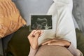 Top view pregnant young woman holding ultrasound picture of baby Royalty Free Stock Photo