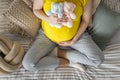 Top view pregnant young woman holding yellow with two cute bear toys on belly sitting on bed Royalty Free Stock Photo