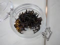 Top view of premium black OOLONG tea leaf blend flavor with dried flowers petals, winter drink, organic in glass jar, pure and