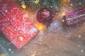 Top view of presents, pine tree branches, Christmas balls and lights on wooden background with snow overlay Royalty Free Stock Photo