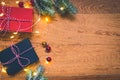 Top view of presents, pine tree branches, Christmas balls and lights on wooden background Royalty Free Stock Photo