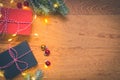 Top view of presents, pine tree branches, Christmas balls and lights on wooden background Royalty Free Stock Photo