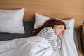 Top view of pretty redhead young woman sleeping well in bed hugging soft white blanket at home. Royalty Free Stock Photo