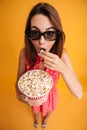 Top view of pretty young woman in 3d glasses eating popcorn, loo Royalty Free Stock Photo