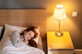 Top view of pretty young woman sleeping well in bed hugging soft white blanket at home, bedside lamp lighting with warm Royalty Free Stock Photo