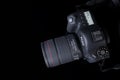 Top view professional digital camera with a zoom lens and a leather strap on a black background with copy space. View Royalty Free Stock Photo