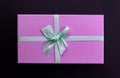 Top view purple present box with green bow on black background Royalty Free Stock Photo