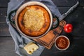 Top view quiche with meat, onions, cheese and tomato pesto in cast iron dishes. Homemade baking. Food still life