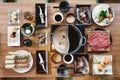 Top view of Rare slices Wagyu A5 beef on bamboo mat with black plate for boiling in Shabu soup hot pot