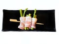 Top view of raw bacon wrapped asparagus on skewer isolated