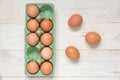 Top view of raw brown chicken eggs in egg carton box on wooden table Royalty Free Stock Photo