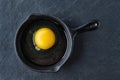 Top view of raw egg in small cast-iron skillet