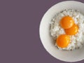 top view of 3 raw eggs over cooked rice, preparing for fried rice menu, home cooking on color background with copy space and Royalty Free Stock Photo