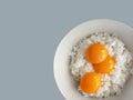 top view of 3 raw eggs over cooked rice, preparing for fried rice menu, home cooking on color background with copy space and Royalty Free Stock Photo