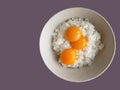 top view of 3 raw eggs over cooked rice, preparing for fried rice menu, home cooking on color background Royalty Free Stock Photo