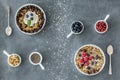 Top view of raw food diet - vegan tarts with nuts, seeds and berries, cups with ingredients and coconut shrims