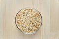 Raw oat flakes in bowl on wooden background. Uncooked oatmeals. Healthy food, dieting concept. Healthy lifestyle Royalty Free Stock Photo