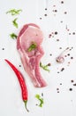 Top view raw pork chop steak and garlic, chili pepper on white wooden background Royalty Free Stock Photo