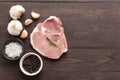 Top view raw pork chop steak and garlic, pepper, salt on wooden Royalty Free Stock Photo