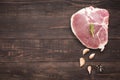 Top view raw pork chop steak and garlic, pepper on wooden background Royalty Free Stock Photo