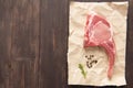 Top view raw pork chop steak on paper on wooden background Royalty Free Stock Photo