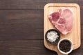 Top view raw pork chop steak and salt, pepper on wooden backgrou Royalty Free Stock Photo