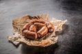 Top of view raw small cocktail sausages on cutting board