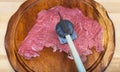 Top view of raw veal are beat by meat tenderizer