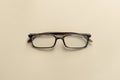 Top view of reading glasses on a cream table Royalty Free Stock Photo